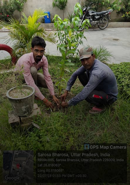 A student planting a sappling with ITI teacher